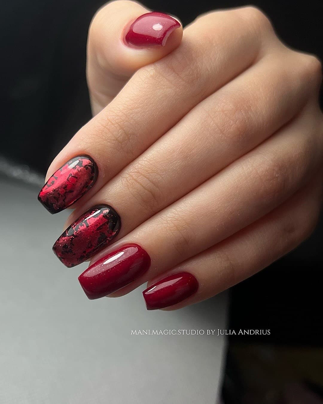 Red manicure with hand-placed foil art